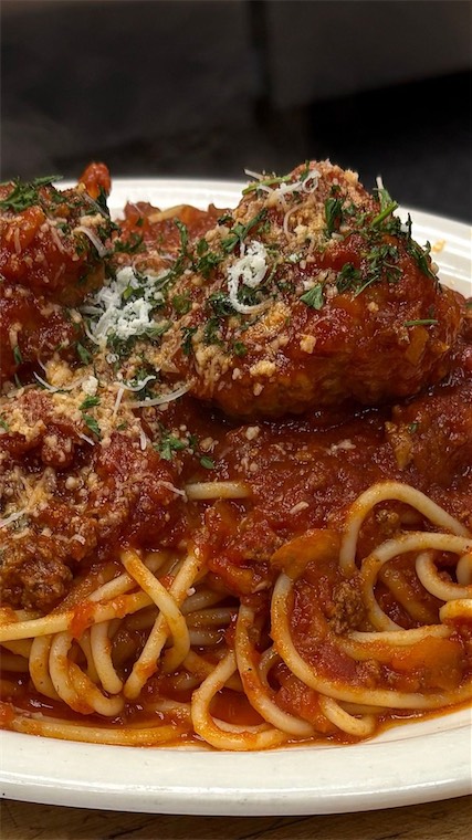 Spaghetti and meatballs topped with Parmesan