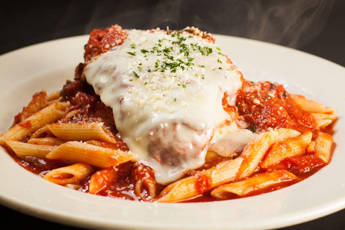 Chicken Parmigiana with melted mozzarella over penne in marinara