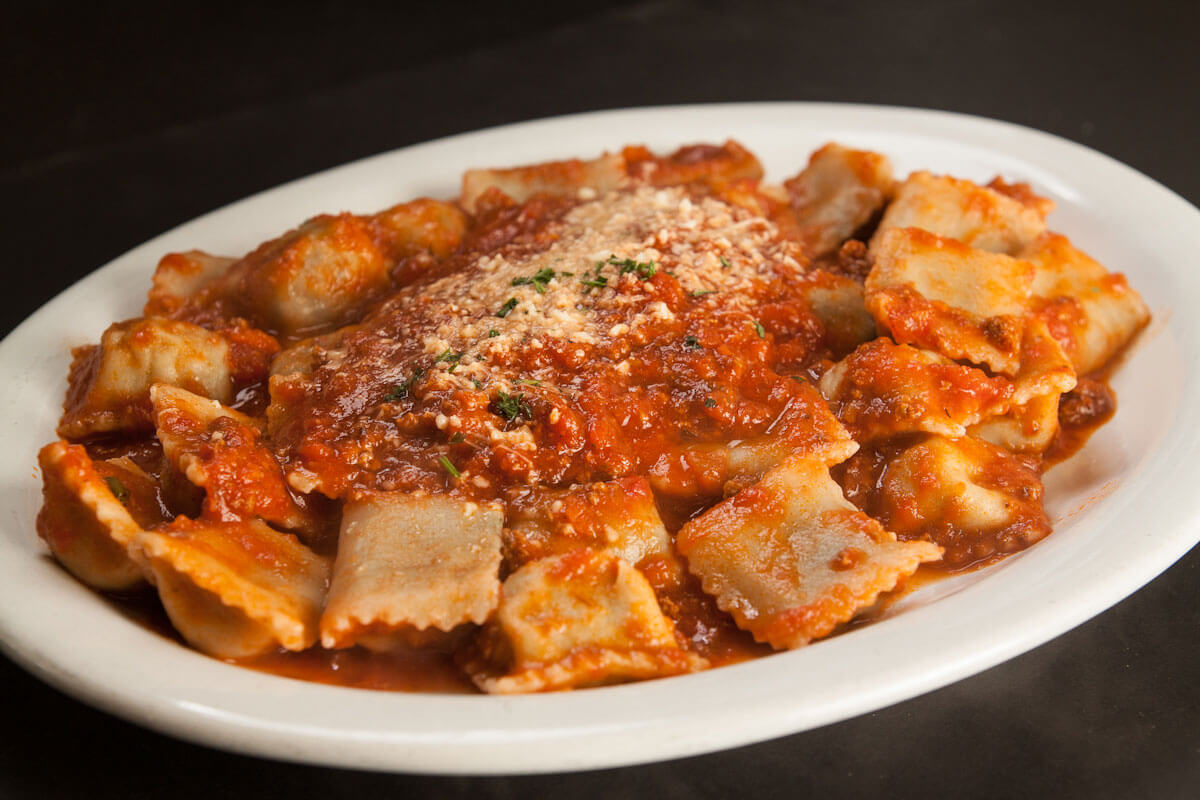 Meat ravioli in marinara sauce topped with Parmesan