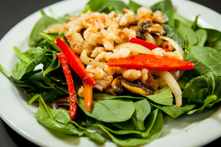 Shrimp salad on fresh spinach with red bell peppers